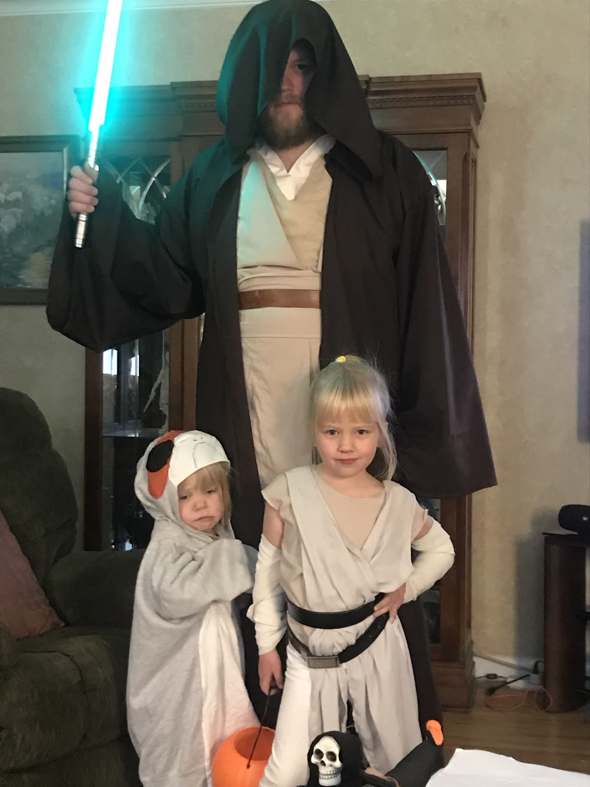 Hooded jedi master with two young padawans in costume